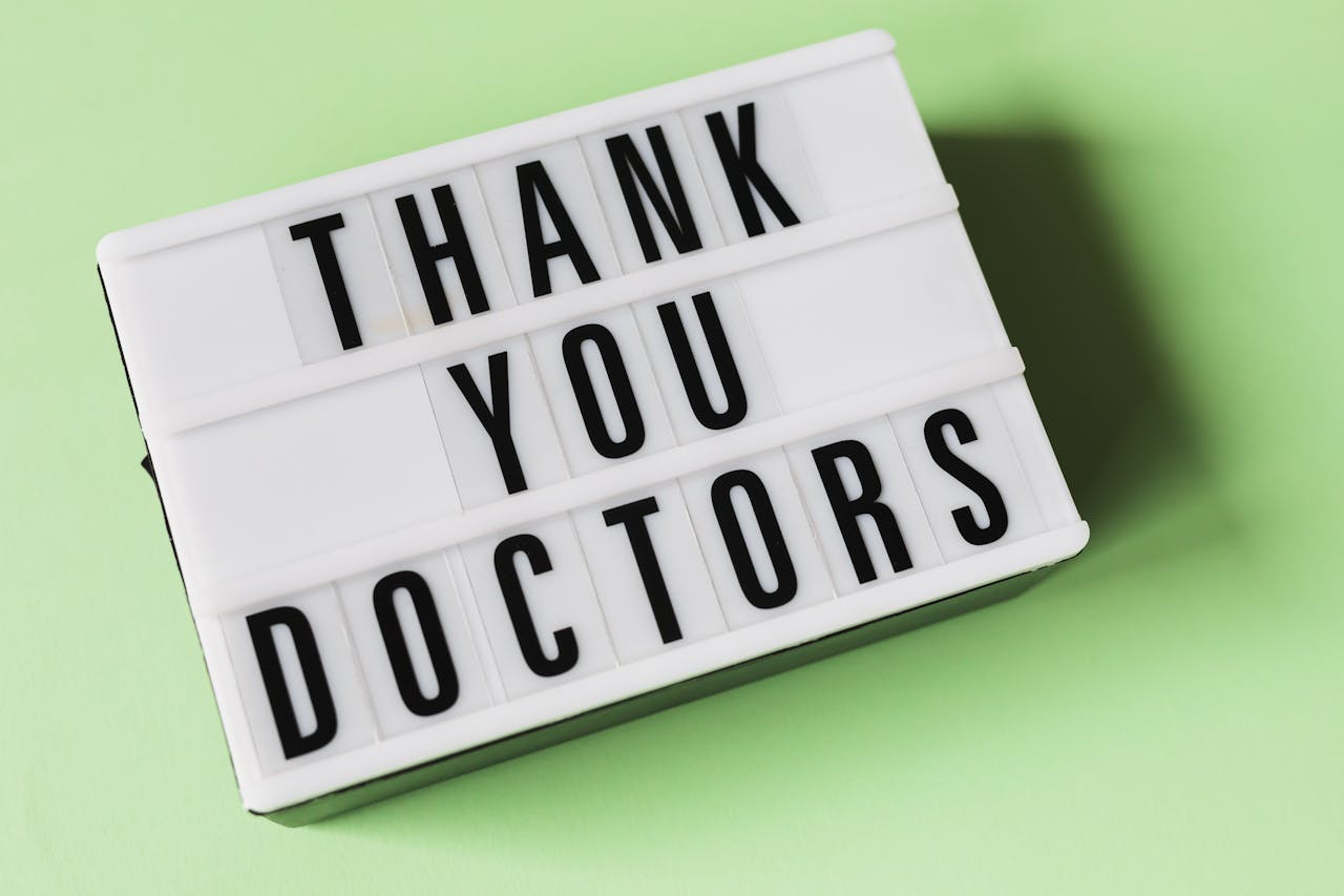 services-01 From above of vintage light box with THANK YOU DOCTORS gratitude message placed on green surface
